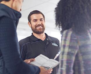 Ford service man helping clients Ford service man helping clients